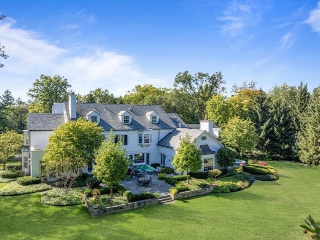 5 Woodley Rd, Winnetka, IL 60093 - back of house with a patio area, a yard, and a chimney