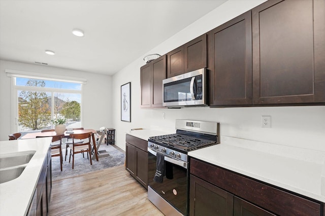 2029 Magnolia Ln, Wonder Lake, IL 60097 - kitchen featuring appliances with stainless steel finishes, light wood-style floors, light countertops, dark brown cabinets, and recessed lighting