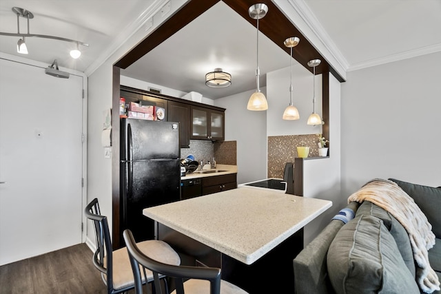 4343 N Clarendon Ave Unit 2309, Chicago, IL 60613 - kitchen with dark brown cabinets, dark wood-style flooring, light countertops, crown molding, and tasteful backsplash