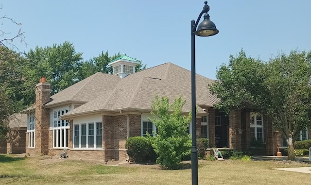 130 Clubhouse Ln Unit 029, Oswego, IL 60543 - view of home's exterior featuring brick siding, a yard, and roof with shingles