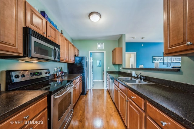 130 Clubhouse Ln Unit 029, Oswego, IL 60543 - kitchen with appliances with stainless steel finishes, light wood-style flooring, and brown cabinets