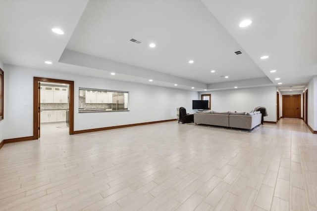 12243 179th St, Mokena, IL 60448 - unfurnished living room featuring a tray ceiling, recessed lighting, and light wood-style flooring