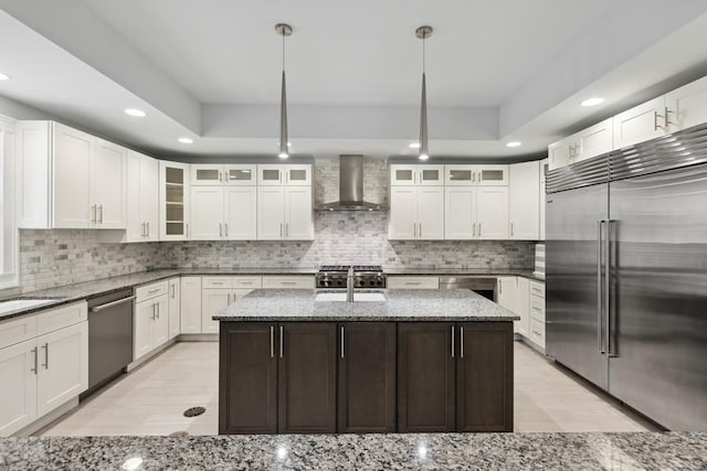 12243 179th St, Mokena, IL 60448 - kitchen featuring appliances with stainless steel finishes, wall chimney exhaust hood, recessed lighting, light wood-style flooring, and a kitchen island with sink