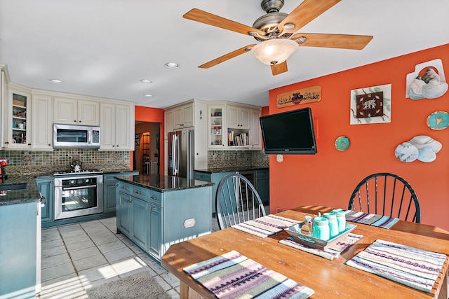 1044 Inverness Ln, Itasca, IL 60143 - kitchen with stainless steel appliances, tasteful backsplash, ceiling fan, a kitchen island, and glass insert cabinets
