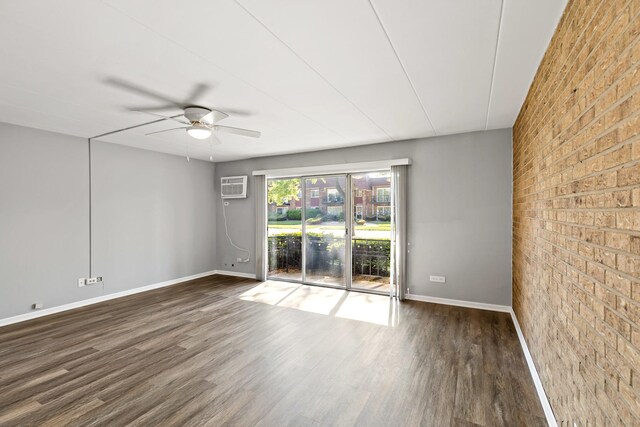 18205 Hart Dr Unit 1A, Homewood, IL 60430 - empty room with brick wall, wood finished floors, a ceiling fan, a wall mounted AC, and an accent wall