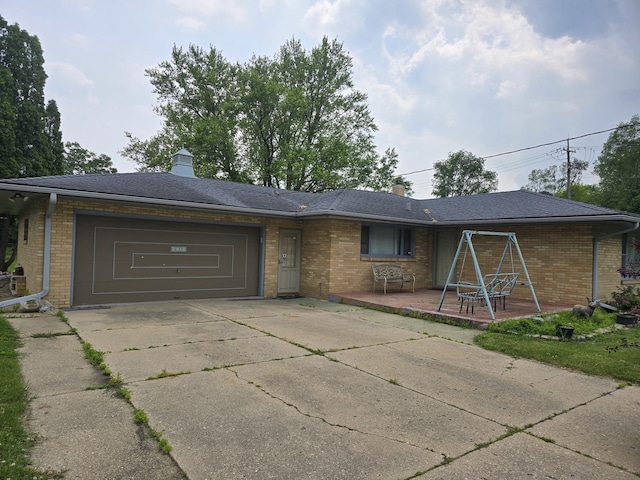 2916 School St, Rockford, IL 61101 - view of front of home with brick siding, a garage, concrete driveway, and a chimney