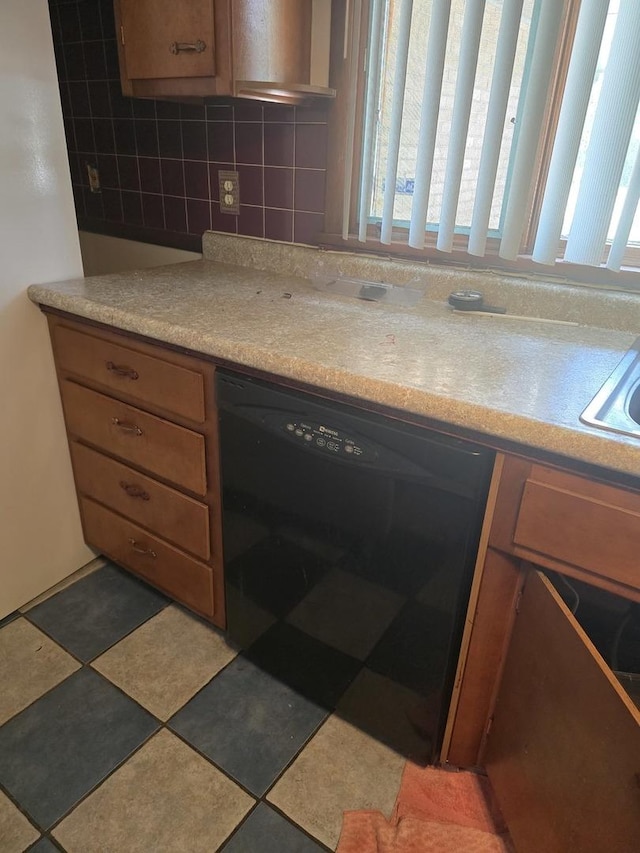 2916 School St, Rockford, IL 61101 - kitchen featuring black dishwasher, light countertops, brown cabinetry, and backsplash