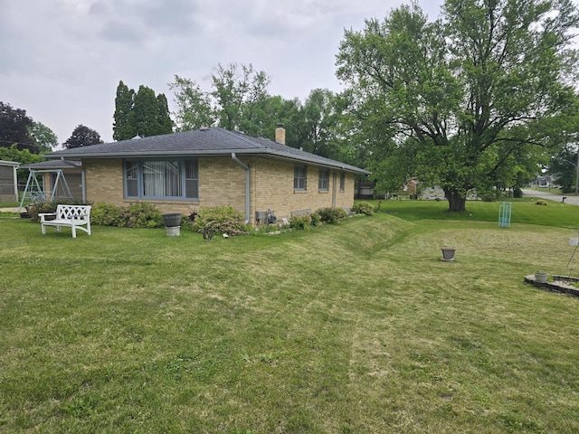 2916 School St, Rockford, IL 61101 - view of side of property featuring a yard, brick siding, and a chimney