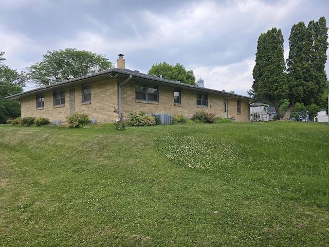 2916 School St, Rockford, IL 61101 - rear view of house with a chimney, brick siding, and a lawn