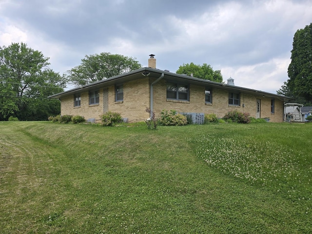 2916 School St, Rockford, IL 61101 - view of side of property featuring a chimney, brick siding, and a lawn