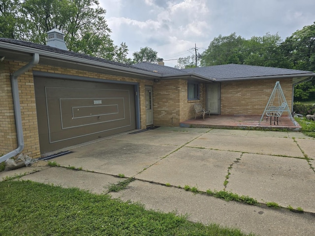 2916 School St, Rockford, IL 61101 - view of front of house with driveway, brick siding, an attached garage, and a chimney