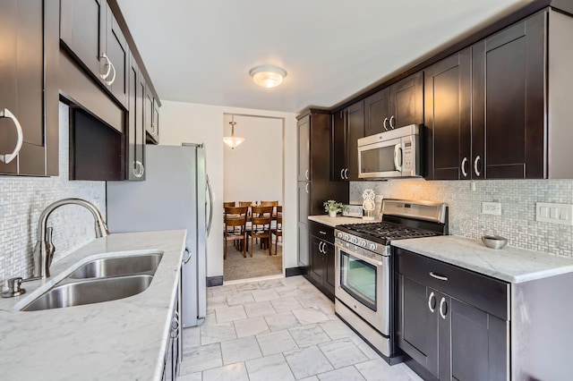 1240 Winfield Ct Unit 4, Roselle, IL 60172 - kitchen with stainless steel appliances, dark brown cabinets, light stone counters, backsplash, and decorative light fixtures