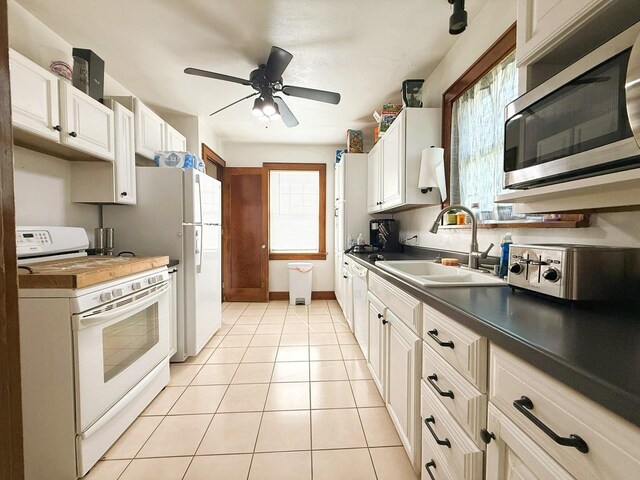 405 N Division Ave, Polo, IL 61064 - kitchen featuring white appliances, dark countertops, ceiling fan, light tile patterned floors, and white cabinets