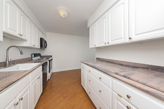 940 W Glenlake Ave Unit 24C, Chicago, IL 60660 - kitchen featuring white range with electric cooktop, light wood-type flooring, white cabinetry, and black microwave