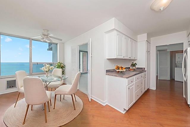 940 W Glenlake Ave Unit 24C, Chicago, IL 60660 - kitchen with white cabinets, light wood finished floors, dark countertops, a ceiling fan, and a water view