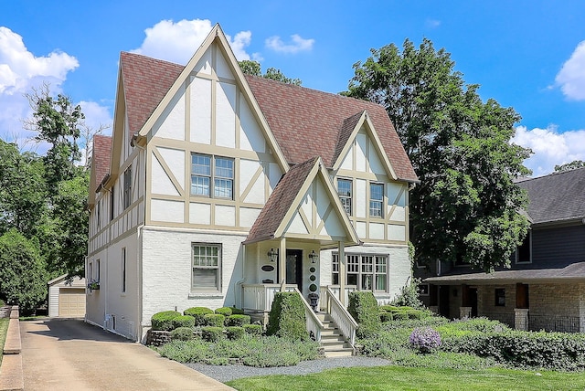 4907 Northcott Ave, Downers Grove, IL 60515 - english style home with stucco siding, an outbuilding, covered porch, a detached garage, and roof with shingles