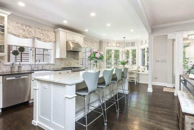 4907 Northcott Ave, Downers Grove, IL 60515 - kitchen with appliances with stainless steel finishes, under cabinet range hood, decorative backsplash, a center island, and recessed lighting