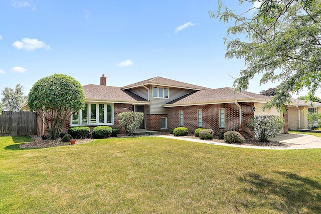 7617 Sycamore Dr, Orland Park, IL 60462 - split level home with a garage, brick siding, a chimney, and driveway
