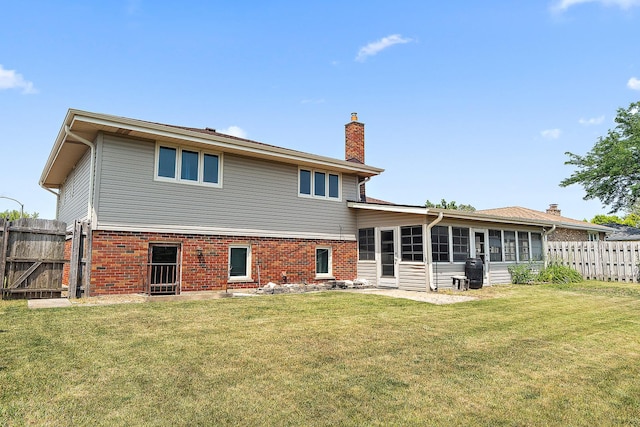7617 Sycamore Dr, Orland Park, IL 60462 - rear view of house with a chimney, a fenced backyard, brick siding, and a sunroom