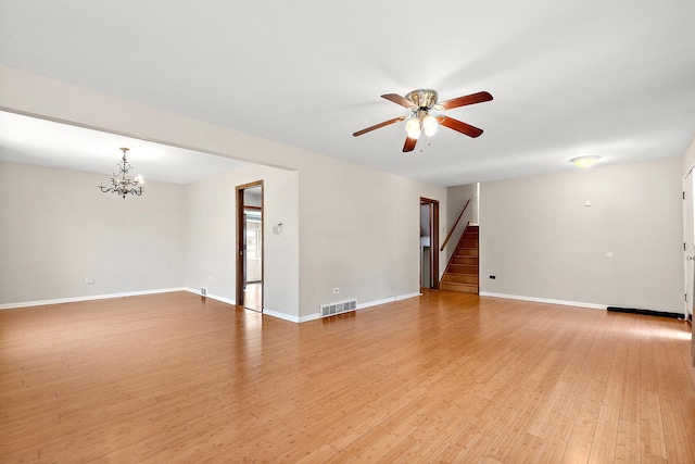 7617 Sycamore Dr, Orland Park, IL 60462 - spare room with a chandelier, stairway, a ceiling fan, and light wood-style floors