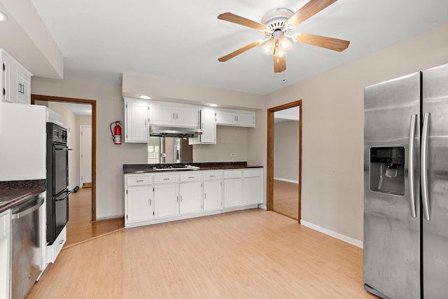 7617 Sycamore Dr, Orland Park, IL 60462 - kitchen with stainless steel appliances, dark countertops, light wood-style floors, a ceiling fan, and white cabinets