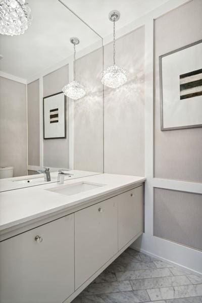 34 E Bellevue Pl, Chicago, IL 60611 - bathroom featuring a chandelier, marble finish floors, and vanity