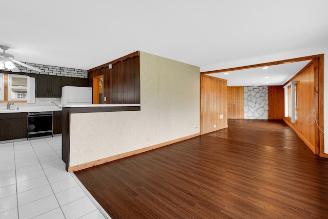 8201 Paloma Dr, Orland Park, IL 60462 - kitchen featuring black dishwasher, fridge, light countertops, ceiling fan, and wood walls