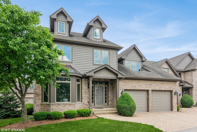 1803 Rizzi Ln, Bartlett, IL 60103 - view of front of home featuring a garage, decorative driveway, brick siding, and a shingled roof