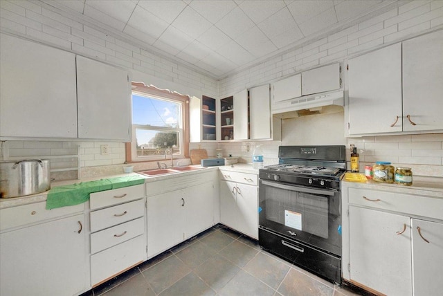 302 S Leney St, Ogden, IL 61859 - kitchen featuring gas stove, under cabinet range hood, light countertops, decorative backsplash, and dark tile patterned floors
