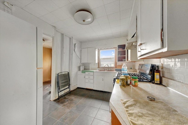 302 S Leney St, Ogden, IL 61859 - kitchen featuring range with gas stovetop, light countertops, white cabinets, under cabinet range hood, and tile patterned floors