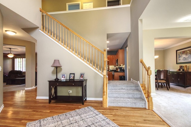 8307 Newbridge Ct, Joliet, IL 60431 - stairway with wood finished floors, a ceiling fan, a towering ceiling, and ornamental molding