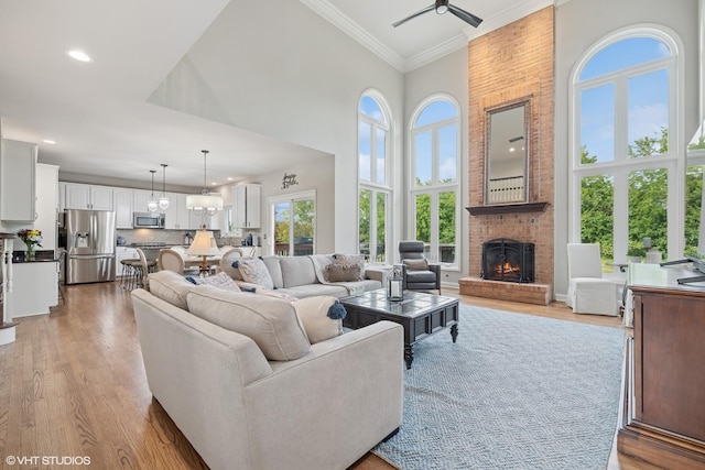 25397 N Northbridge Rd, Hawthorn Woods, IL 60047 - living room featuring crown molding, a high ceiling, light wood-style flooring, a brick fireplace, and ceiling fan