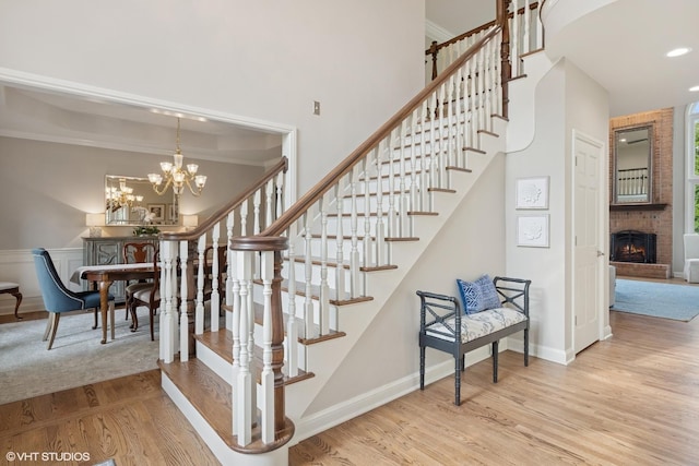 25397 N Northbridge Rd, Hawthorn Woods, IL 60047 - stairway with wood finished floors, a chandelier, a fireplace, a high ceiling, and recessed lighting