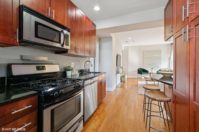 4332 N Sacramento Ave Unit 3S, Chicago, IL 60618 - kitchen with stainless steel appliances, light wood-style flooring, dark stone countertops, recessed lighting, and open floor plan