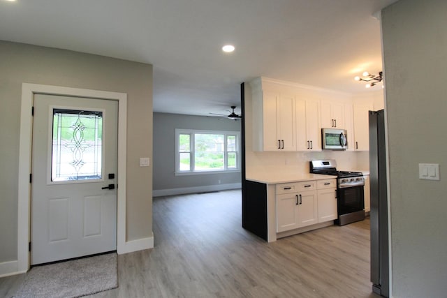 957 E Eagle St, Kankakee, IL 60901 - kitchen with appliances with stainless steel finishes, light wood-type flooring, white cabinets, light countertops, and open floor plan