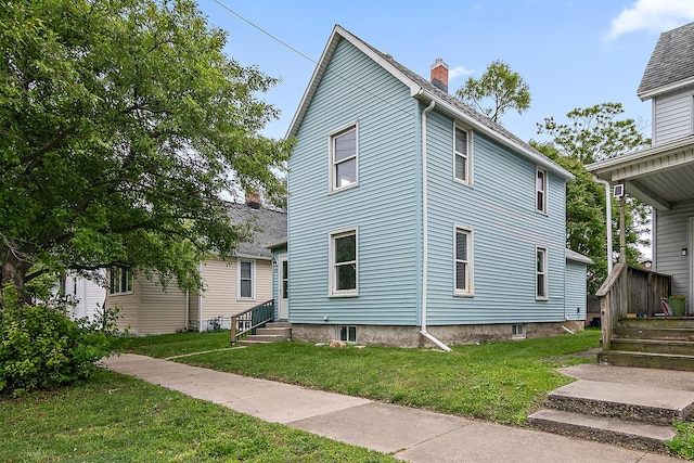 554 W Station St, Kankakee, IL 60901 - view of home's exterior with entry steps, a chimney, and a lawn