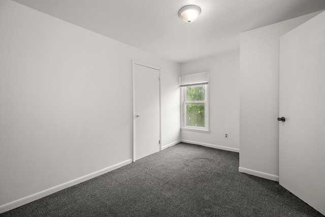 554 W Station St, Kankakee, IL 60901 - unfurnished bedroom featuring dark carpet and baseboards