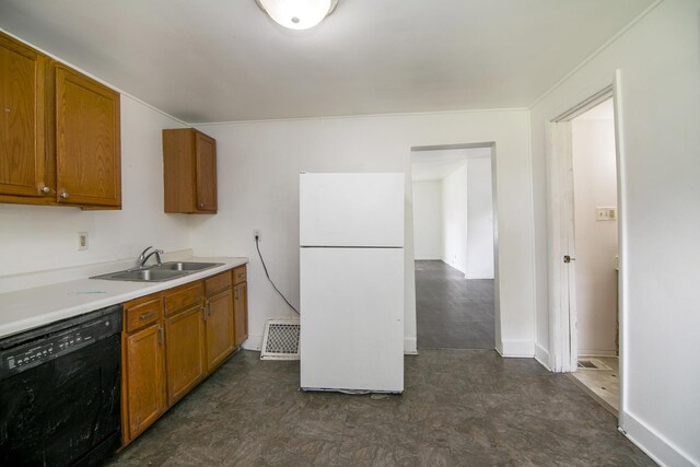 554 W Station St, Kankakee, IL 60901 - kitchen featuring black dishwasher, freestanding refrigerator, dark flooring, brown cabinetry, and light countertops
