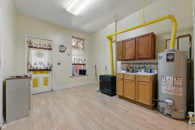 1448 W Taylor St, Chicago, IL 60607 - kitchen with gas water heater, light wood-type flooring, light countertops, brown cabinetry, and tasteful backsplash