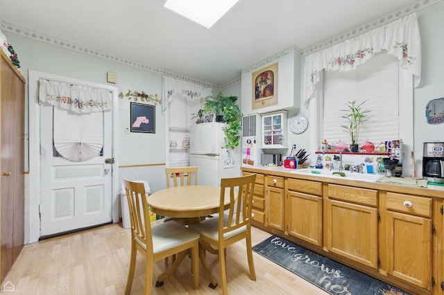 1448 W Taylor St, Chicago, IL 60607 - kitchen with light wood-style floors, light countertops, freestanding refrigerator, and brown cabinetry