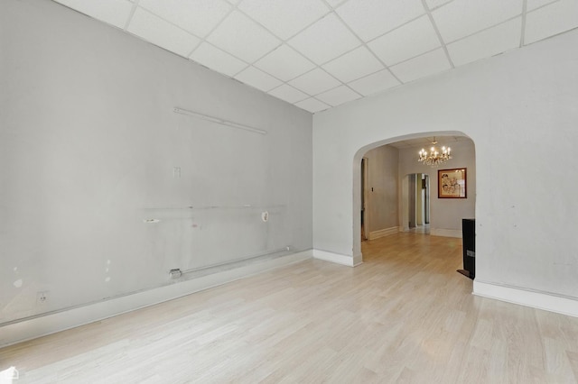1448 W Taylor St, Chicago, IL 60607 - unfurnished room with arched walkways, a drop ceiling, light wood-style floors, and a chandelier
