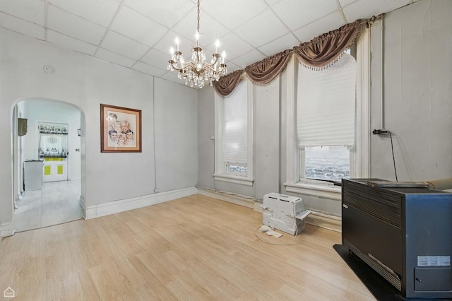 1448 W Taylor St, Chicago, IL 60607 - unfurnished dining area featuring arched walkways, a drop ceiling, a chandelier, wood finished floors, and heating unit