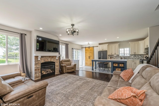 253 Brookhaven Trl, Pingree Grove, IL 60140 - living area with a barn door, wood finished floors, recessed lighting, a fireplace, and a chandelier