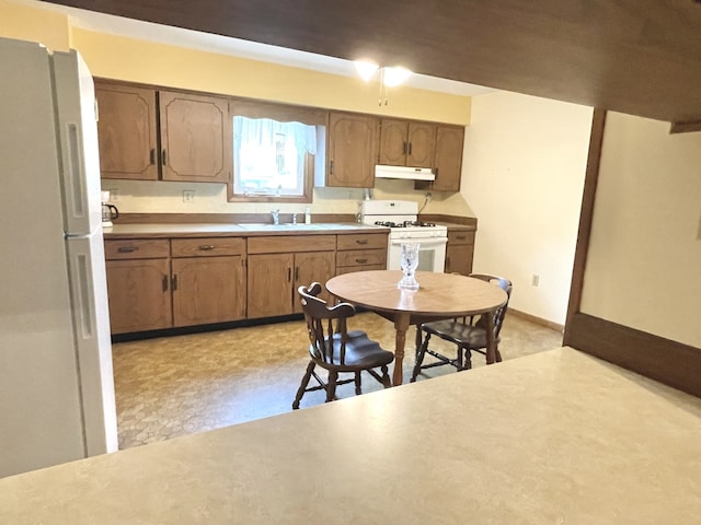 1660 Laharpe St, Lasalle, IL 61301 - kitchen featuring white appliances, under cabinet range hood, brown cabinets, light countertops, and light floors