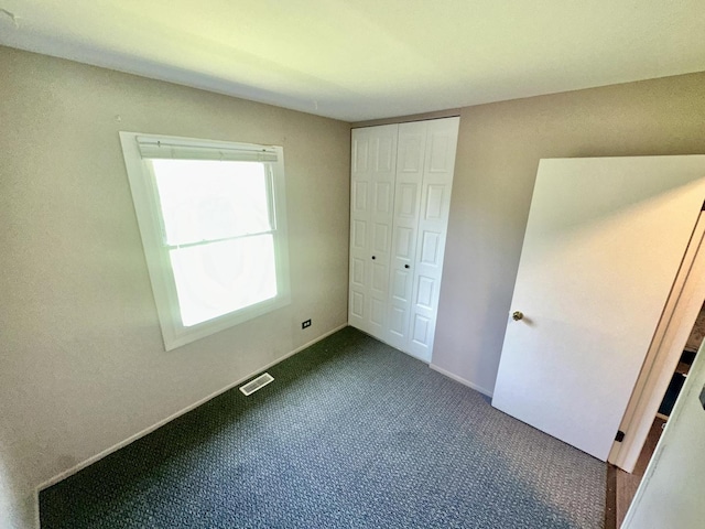 1015 Hastings Ln, Hanover Park, IL 60133 - unfurnished bedroom with dark carpet and a closet