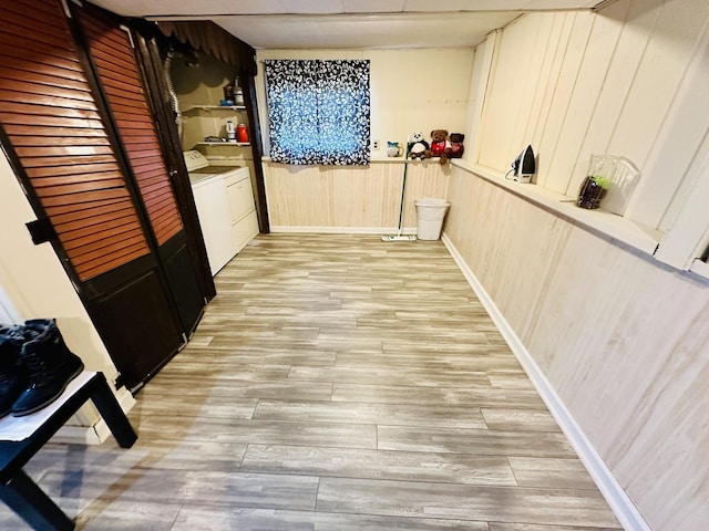 1015 Hastings Ln, Hanover Park, IL 60133 - hall featuring separate washer and dryer, light wood-type flooring, and wood walls