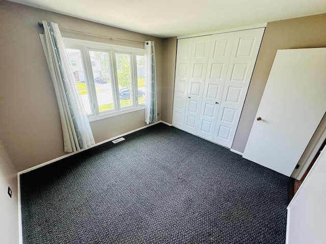 1015 Hastings Ln, Hanover Park, IL 60133 - unfurnished bedroom with a closet and dark colored carpet