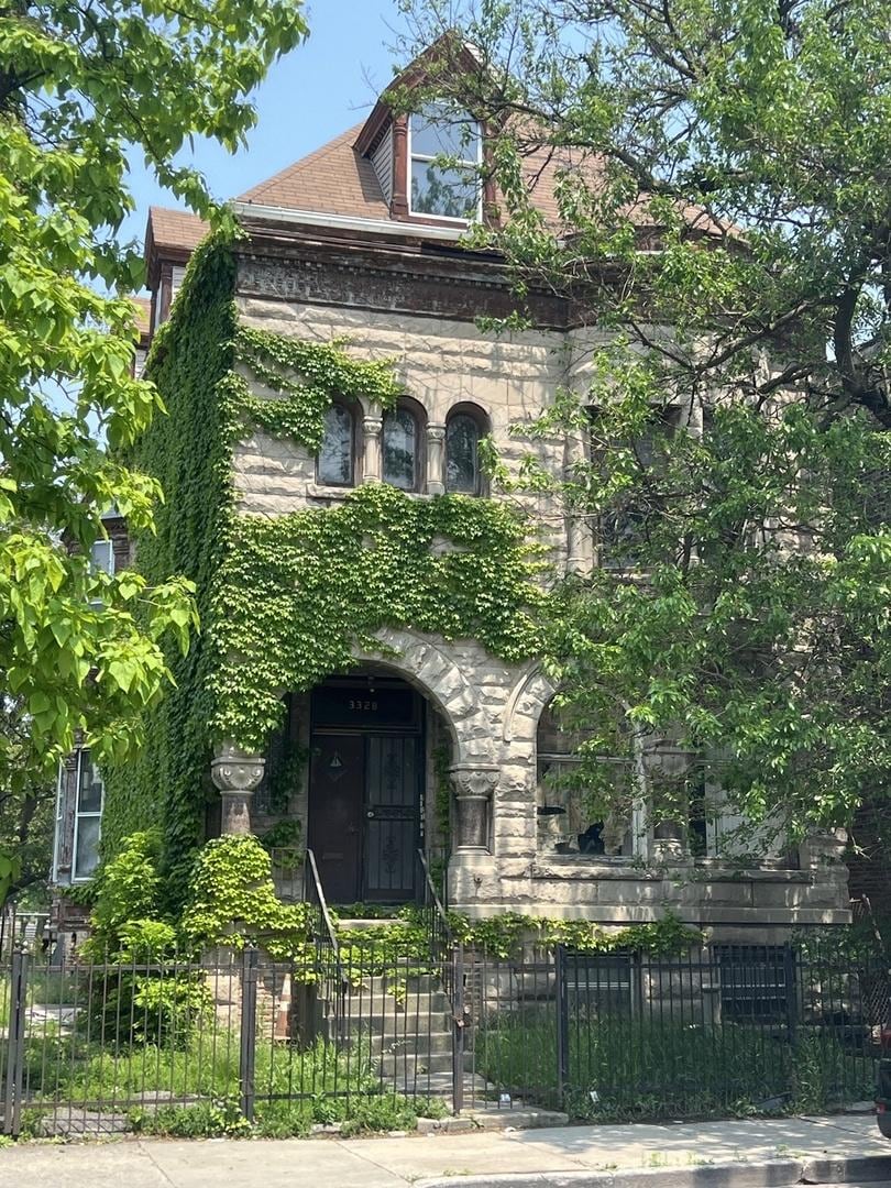 3328 W Warren Blvd, Chicago, IL 60624 - view of front facade with a fenced front yard and stone siding