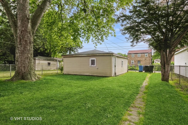 fenced backyard featuring an outbuilding