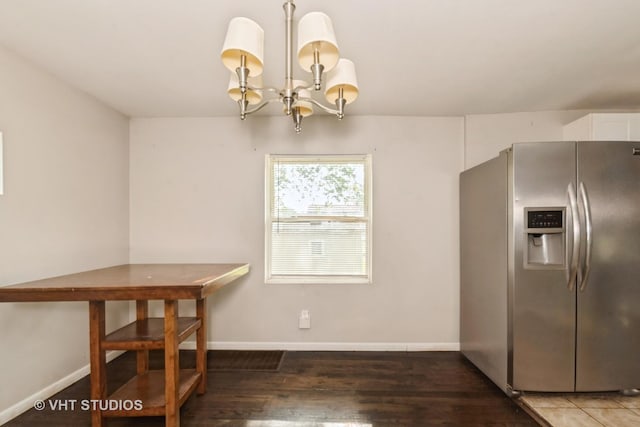 unfurnished dining area featuring a chandelier and wood finished floors